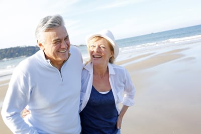 Senior couple walking on the beach in fall season-1