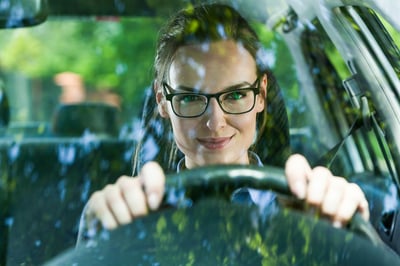 Young attractive woman in glasses driving a car