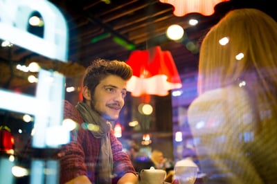 Young romantic couple eating at city restaurant by evening